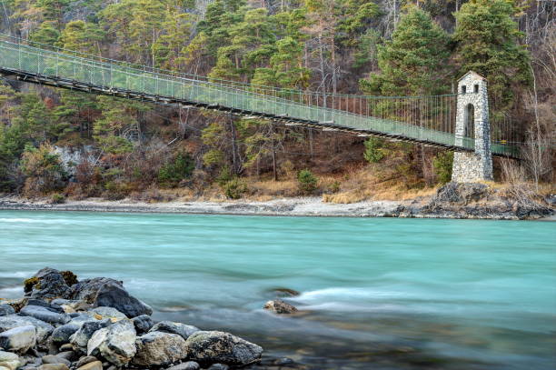 The suspension bridge of Stams is the hiking trail over the river Inn. stock photo