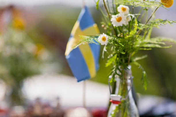 The Swedish flag Flowers and the Swedish flag during midsummer. swedish flag photos stock pictures, royalty-free photos & images