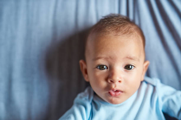 The sweetest face in the world Portrait of an adorable baby boy laying on the bed at home baby boys stock pictures, royalty-free photos & images