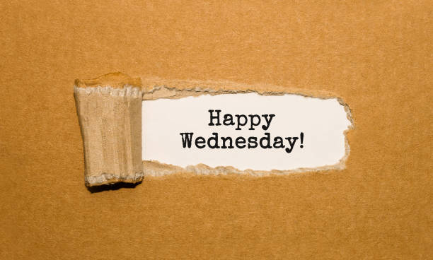 The text Happy Wednesday appearing behind torn brown paper stock photo