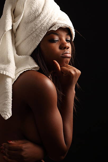 The thinker The thinker. African woman topless with bath towel on her head. chiaroscuro stock pictures, royalty-free photos & images