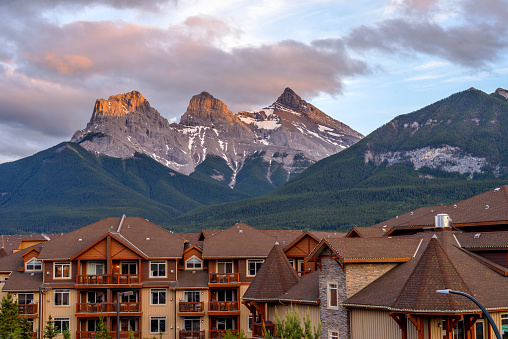 Canmore, Alberta, Canada - June 9, 2018: A Spring sunset view of The Three Sisters mountain, seen from mountain resort town of Canmore.