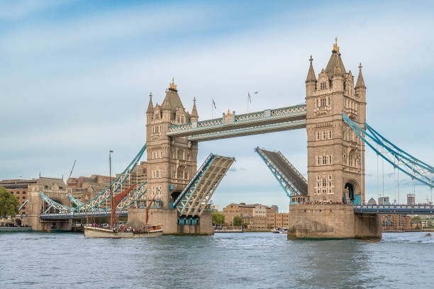The Tower Bridge in London, United Kingdom. The bridge is open and a vessel is passing through  tower bridge stock pictures, royalty-free photos & images