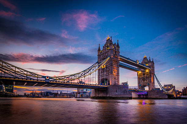 The Tower Bridge of London at dusk A vivid and spectacular view in twilight from the river Thames Southbank overlooking the iconic landmark and famous tourist attraction's night illumination of Tower Bridge in the capital city of London, United Kingdom. Shot with Canon EOS 60D, ISO 100, boosted saturation to emphasize colours, slight vignette added tower bridge stock pictures, royalty-free photos & images