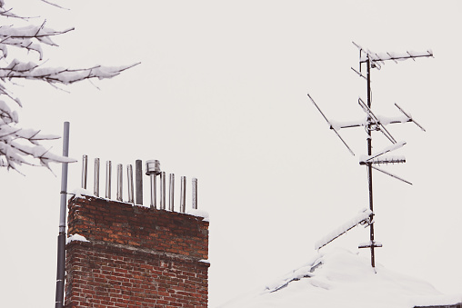 The TV antenna is covered with snow on the roof. Cold winter, , icicle formation, frost and winter weather concept