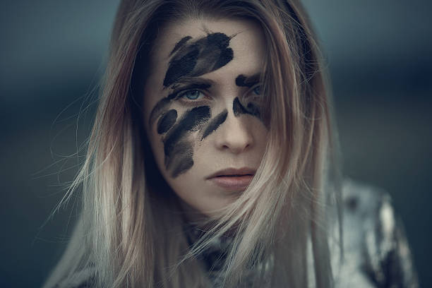 the warrior look blond hair woman attitude with black makeup on her face, feeling agressive and serious. warriors stock pictures, royalty-free photos & images