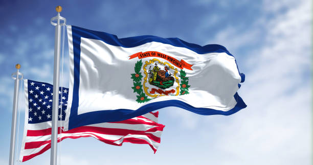 The West Virginia state flag waving along with the national flag of the United States of America. stock photo