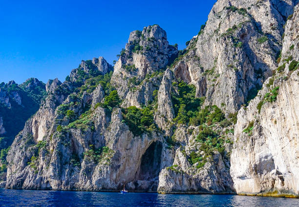 The White Grotto of the island of Capri, Italy.  Coastal Rocks on the Mediterranean Sea at Capri Island from a motorboat​ tour. stock photo