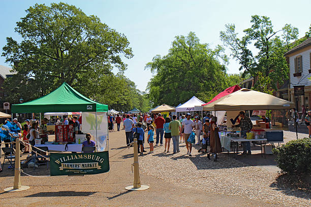 The Williamsburg Farmers Market in Merchants Square Williamsburg, USA - April 21, 2012: Vendors and shoppers at the Williamsburg Farmers Market in Merchants Square williamsburg virginia stock pictures, royalty-free photos & images