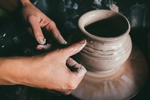 The woman's hands close up, the masterful studio of ceramics works with clay on a potter's wheel