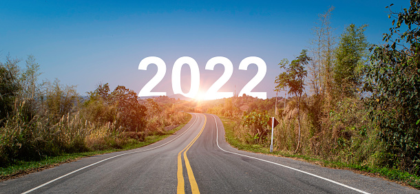 The word 2022 behind the mountain. Nature landscape and asphalt road leading forward to happy new year 2022. Concept for vision new year