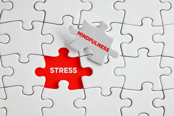 The words stress and mindfulness on missing puzzle pieces. stock photo