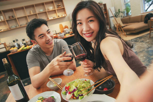 The young couple have dinner at home girl turn to look at camera and smiling stock photo