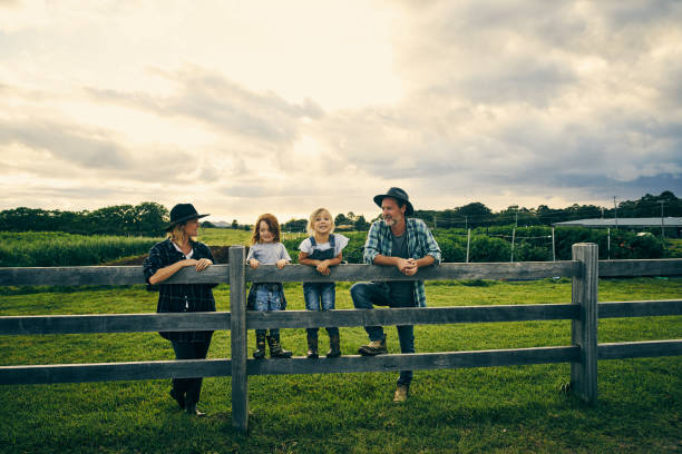 Their little family of four on the farm Full length shot of a family of four standing on their farm homegrown produce photos stock pictures, royalty-free photos & images