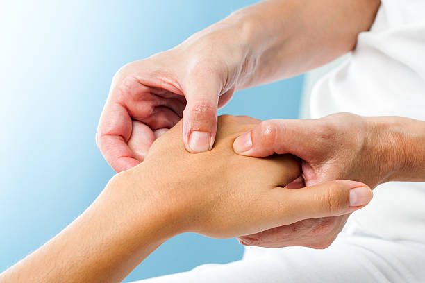 Therapist doing massage on female hand. stock photo