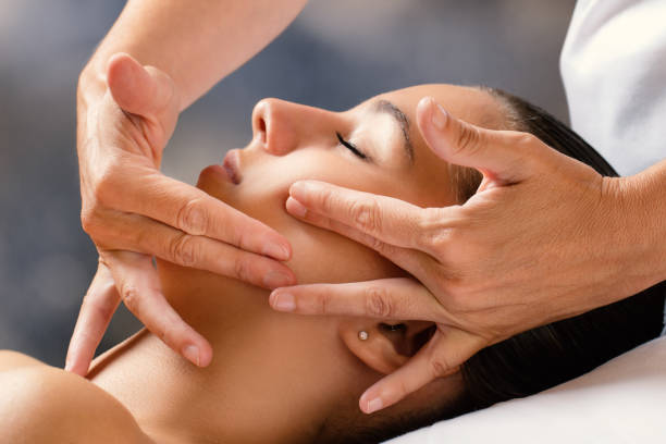 Therapist massaging female face. stock photo