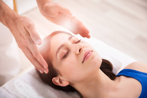 Therapist Performing Reiki Healing Treatment On Woman  reiki healing stock pictures, royalty-free photos & images