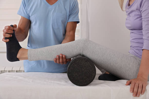 therapeut behandelt knie der sportlerin weibliche patientin, physiotherapie, verletzungsrehabilitation - assistent stock-fotos und bilder