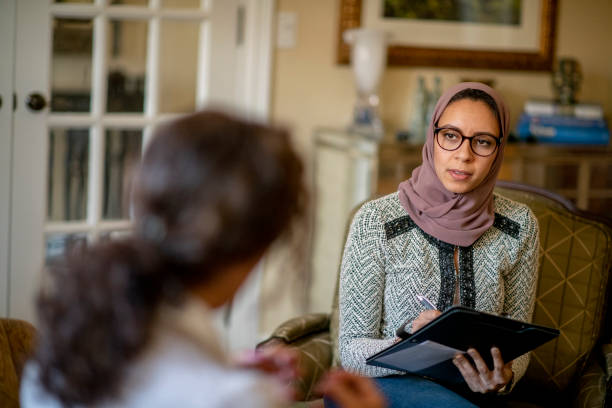 Therapy session Young Muslim woman at a counselling session. psychotherapy photos stock pictures, royalty-free photos & images