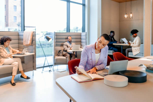 There's no excuse not to succeed Stylish young short haircut businesswoman working in an open plan office hot desking stock pictures, royalty-free photos & images