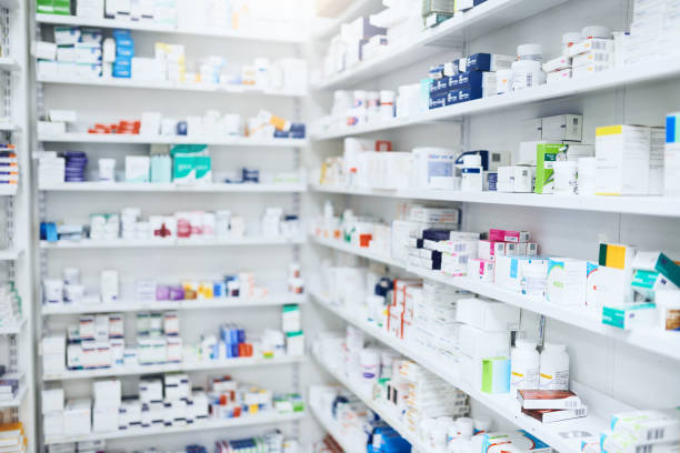Bidikan rak yang diisi dengan berbagai produk obat di apotek