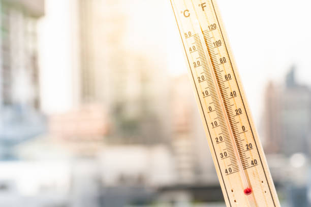Thermometer against the city with hot weather background. stock photo