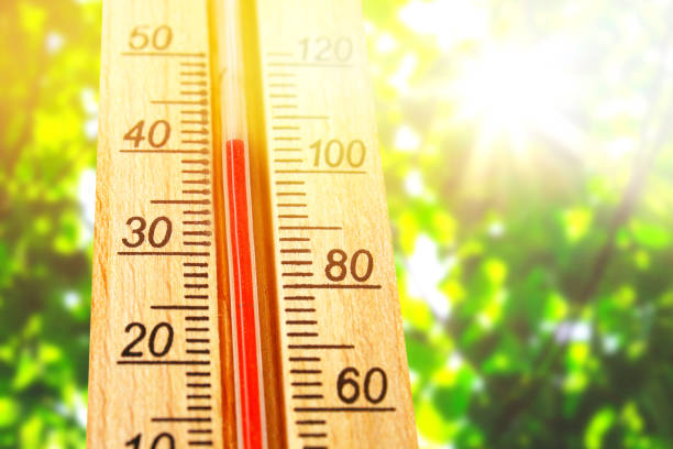 Thermometer displaying high 40 degree hot temperatures in sun summer day. stock photo