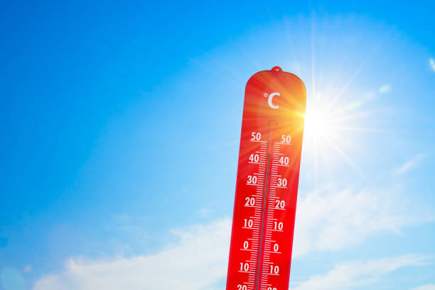 thermometer in front of the sun to represent global warming stock photo