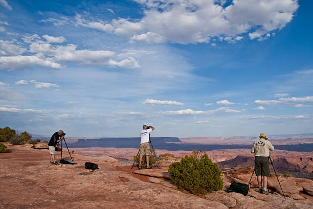Three Photographers Lined Up on the Canyon Rim Canyonlands National Park, Utah, USA - May 17, 2012: These photographers are taking advantage of the evening light and clouds to shoot pictures from Grandview Overlook. jeff goulden canyonlands national park stock pictures, royalty-free photos & images