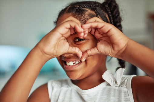 Cropped shot of a young girl forming a heart shape with her hands