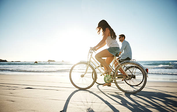 they love long rides on the beach - fietsen strand stockfoto's en -beelden