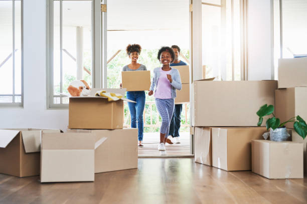 They're all excited about the big move Shot of a happy family carrying boxes into their new home unpacking stock pictures, royalty-free photos & images