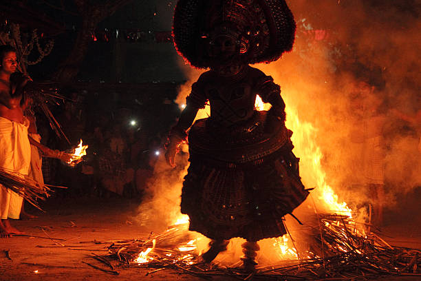 Theyyam performance Kannur, India - January 19,2015 : An unidentified Theyyam artist performs a fire walk ritual in the early morning at the Pilathara Dermal temple in Kannur, Kerala,India. firewalking stock pictures, royalty-free photos & images