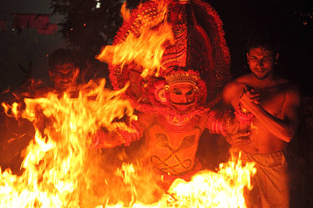 Theyyam performance Kannur, India - January 19,2015 : An unidentified Theyyam artist performs a fire walk ritual in the early morning at the Pilathara Dermal temple in Kannur, Kerala,India. firewalking stock pictures, royalty-free photos & images