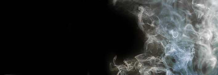 Thick smoke from burning incense on a black background. Banner for design and advertising, panoramic shot. Horizontal format. Place for text