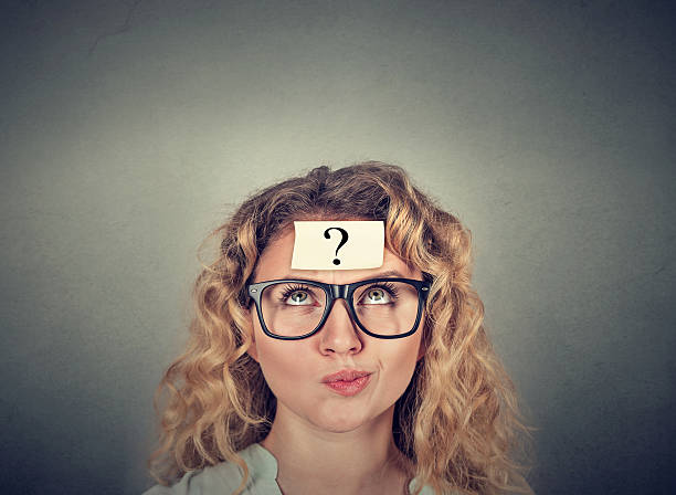 thinking confused woman with question mark stock photo