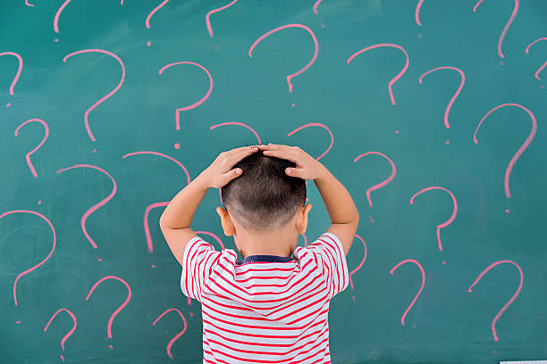 thinking for solution Asian little boy in front of blackboard with question marks. confusion stock pictures, royalty-free photos & images