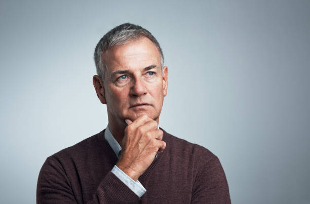 Thinking of all the tomorrows Studio shot of a mature man looking thoughtful against a gray background hand on chin stock pictures, royalty-free photos & images