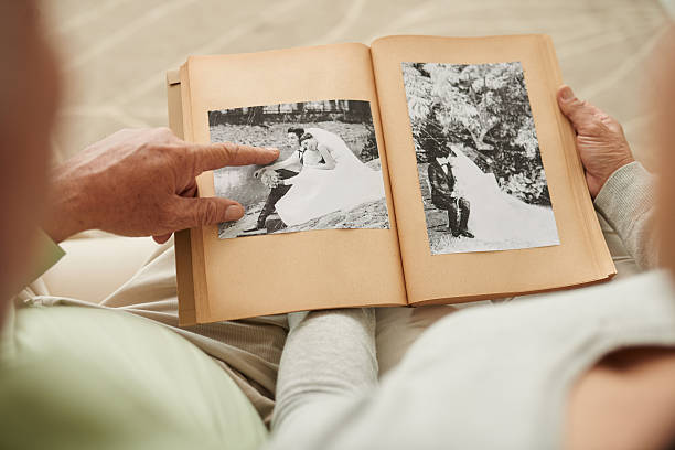 Thinking of old times Senior couple at their wedding photos in photo album looking photos stock pictures, royalty-free photos & images