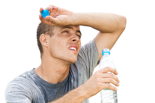 Man drinking water from a bottle on a hot day.