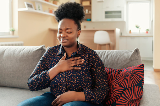 Pressure in the Chest. Close-up Photo of a Stressed Obese African American Woman Who Is Suffering From a Chest Pain and Touching Her Heart Area.
