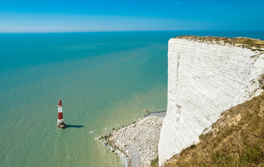 This is a scenic view by day on the blue sea and Beachy head lighthouse, white cliffs of the Seven Sisters, East Sussex, England, UK. Can be used for websites, brochures, posters, printing and design.