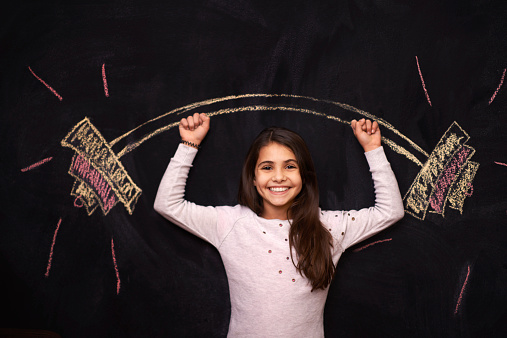 Portrait of a young girl standing in front of a chalkboard drawing of a barbellhttp://195.154.178.81/DATA/shoots/ic_784221.jpg