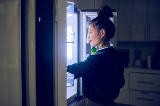 This is exactly what I'm craving Cropped shot of an attractive young woman looking in her fridge for a midnight snack at home refrigerator door stock pictures, royalty-free photos & images