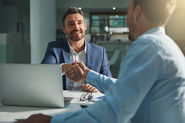 This is the start of great things Shot of two businessmen shaking hands in an office business handshake stock pictures, royalty-free photos & images