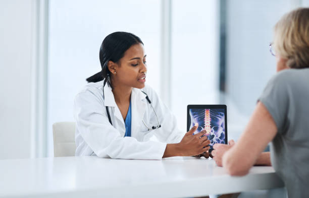 This is why you're feeling pain Shot of a young doctor using a digital tablet during a consultation with a senior woman pelvis stock pictures, royalty-free photos & images