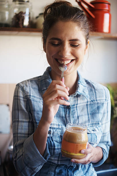 This peanut butter's got me feeling good on the inside! Shot of a beautiful young woman eating peanut butter out of the jar with a spoonhttp://195.154.178.81/DATA/i_collage/pi/shoots/783580.jpg indulgence stock pictures, royalty-free photos & images
