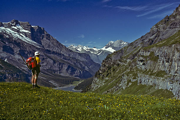 Young Woman Hiking in the Swiss Alps This young woman is hiking in the Swiss Alps above above Oeschinensee near Blumlisalp, Bern, Switzerland. jeff goulden switzerland stock pictures, royalty-free photos & images