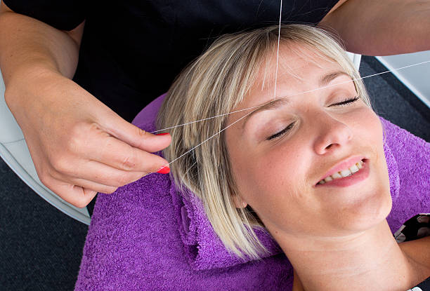 threading hair removal stock photo