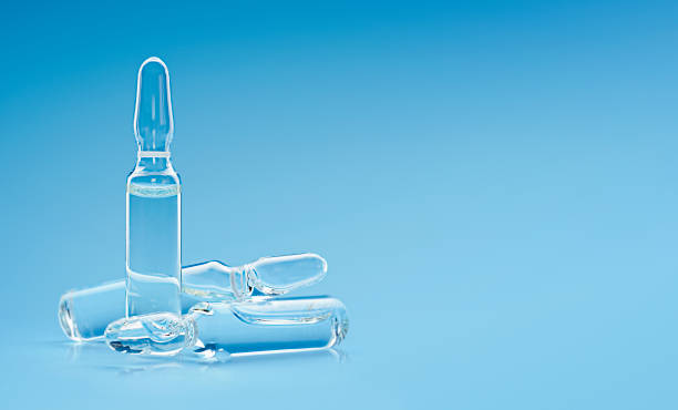 three ampoules three ampoules on a blue background ampoule stock pictures, royalty-free photos & images